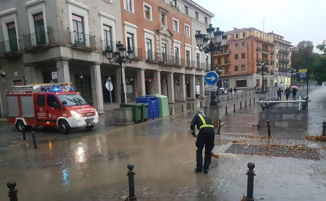 Los bomberos achican el agua en una balsa producida en la avenida del Acueducto.