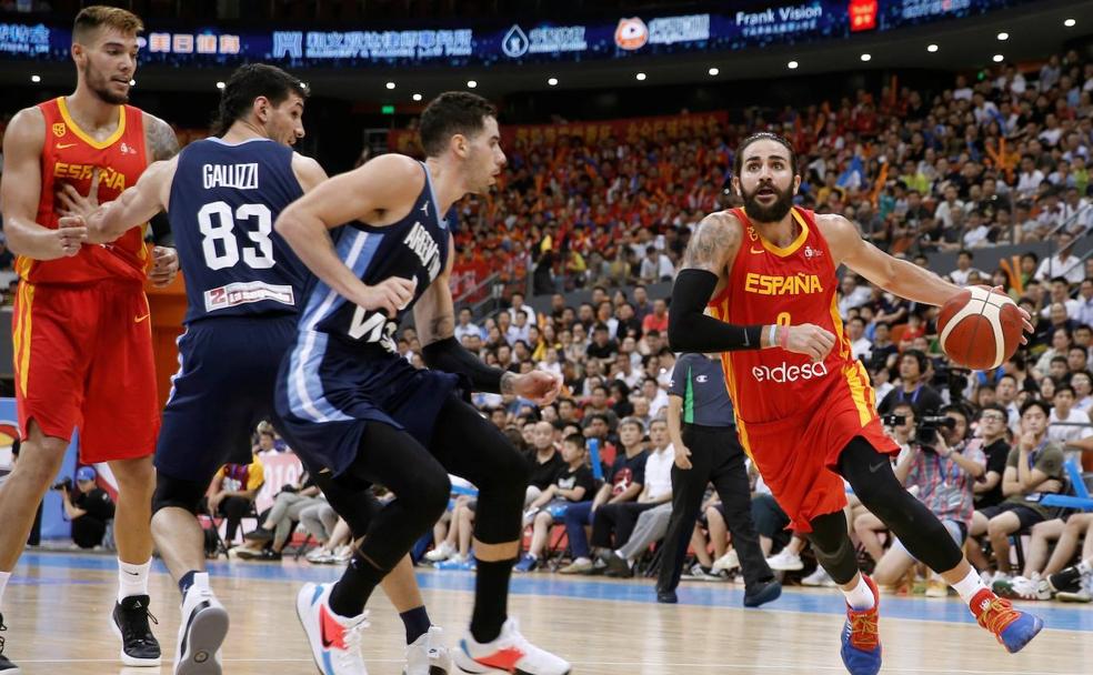 El base de la selección española Ricky Rubio se dispone a entrar a canasta ante la defensa del base argentino Luca Vildoza.