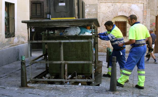 Dos empleados de FCC manipulan los contenedores de la plaza del Platero Oquendo.