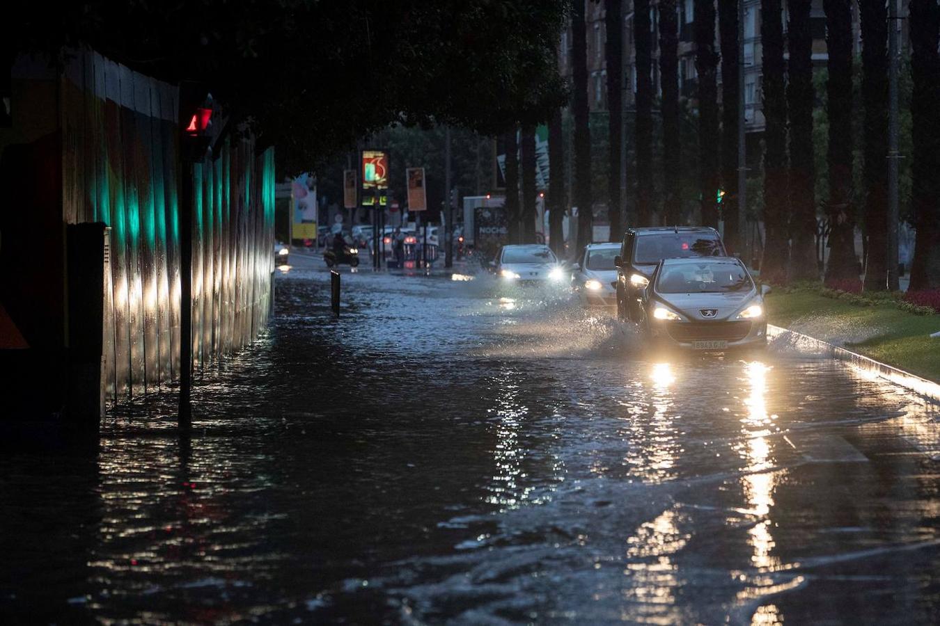 Los coches circulan por las calles de Murcia desbordadas por la riada.