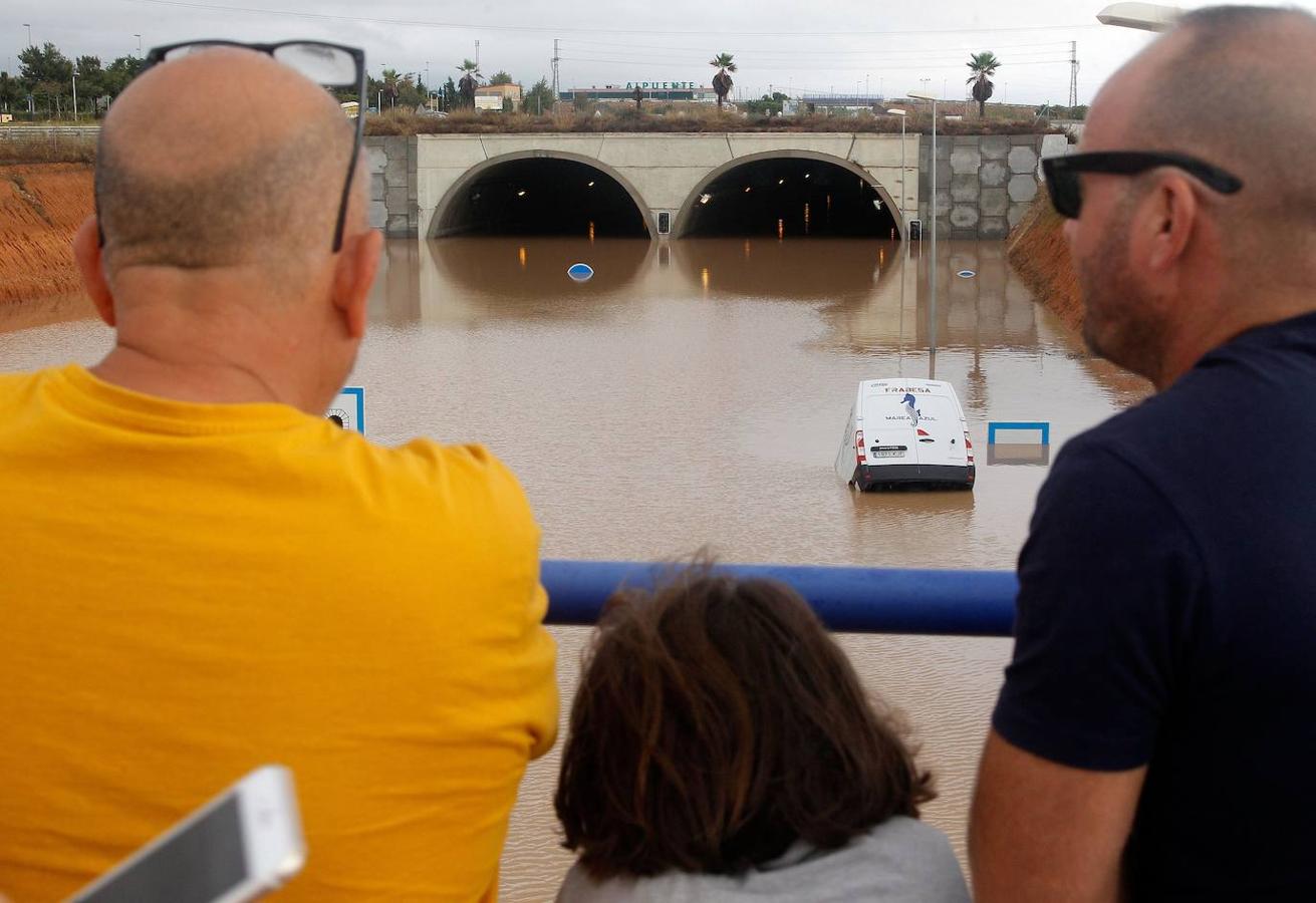 Varios ciudadanos observan la autovía A-7 inundada a su paso por Pinar de la Horadada (Alicante).