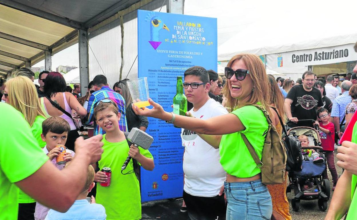 Una mujer escancia sidra junto al centro asturiano. 