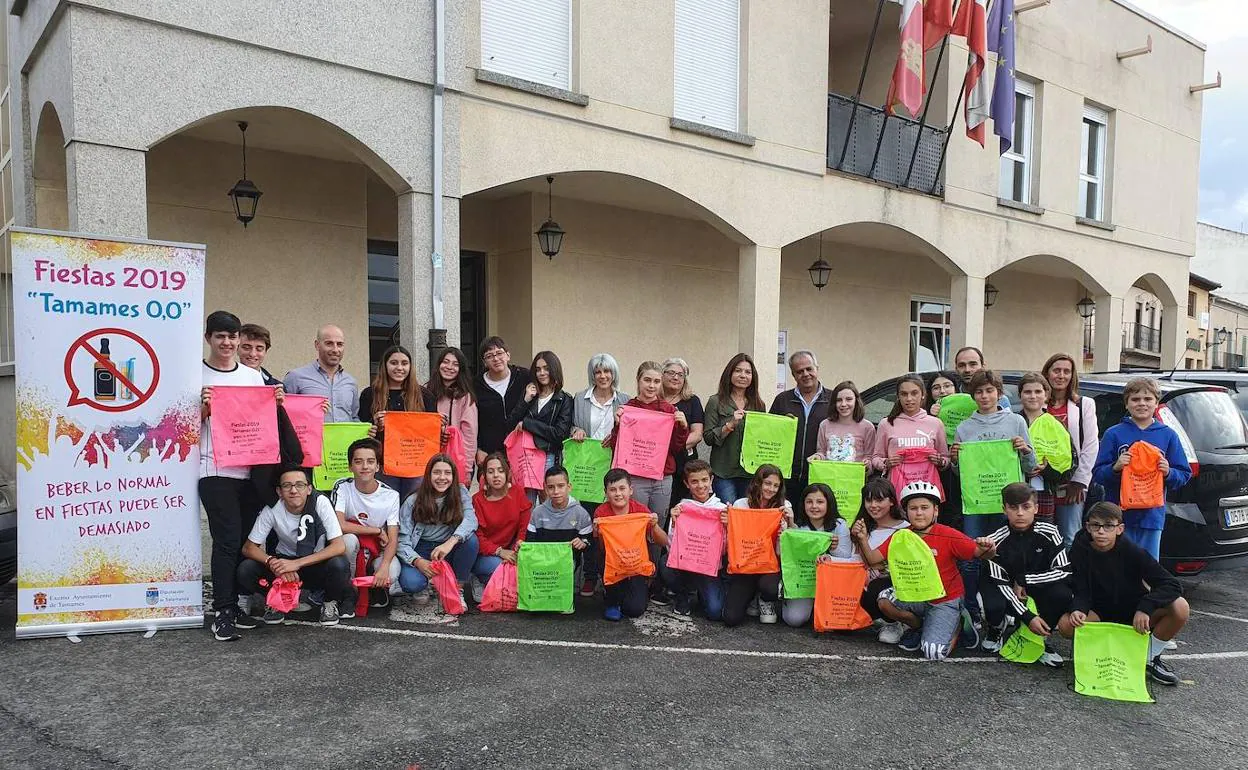 Los jóvenes participantes con los diputados, el alcalde e implicados en la campaña de prevención, muestran las mochilas con el eslogan. 