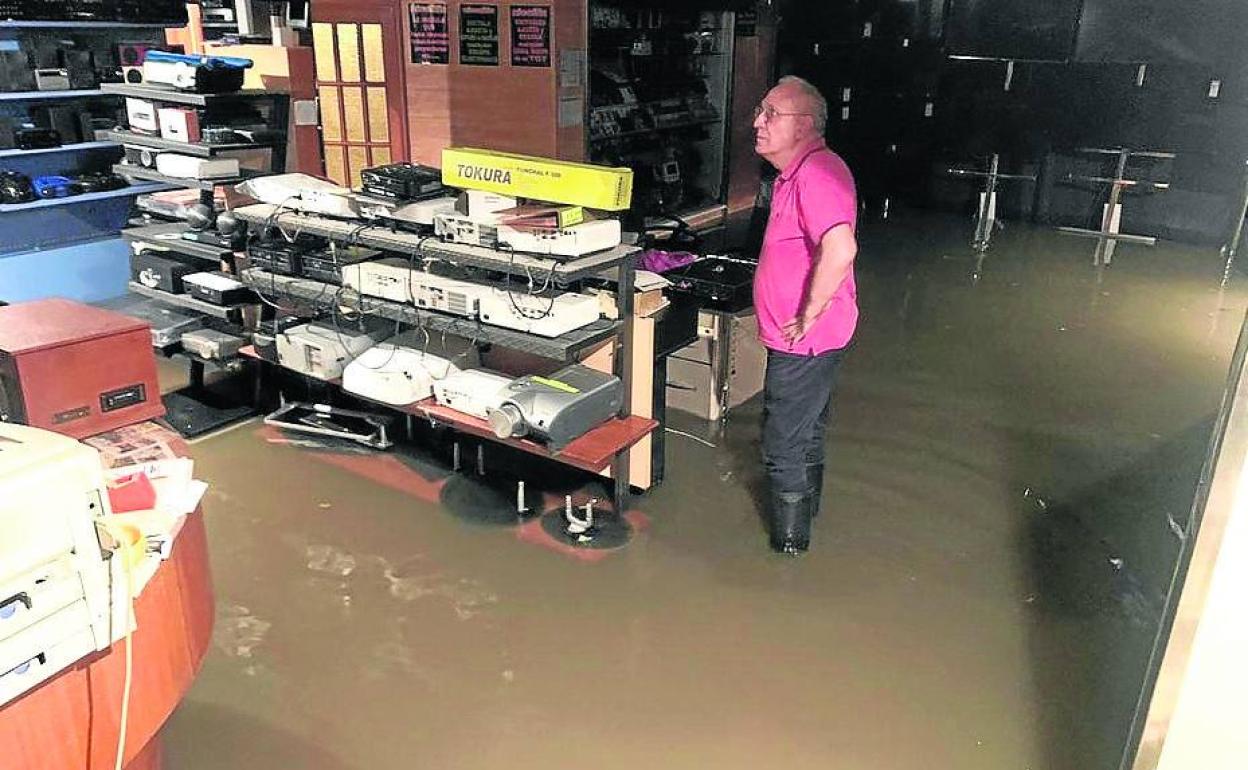 Un trabajador del establecimiento, con el agua casi por las rodillas. 