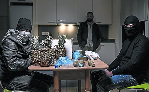 Traficantes de droga ante unas piñas que esconden cocaína en su interior.