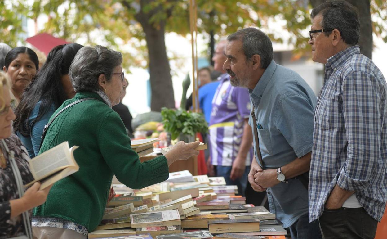 Una mujer pide información sobre uno de los libros a la venta.