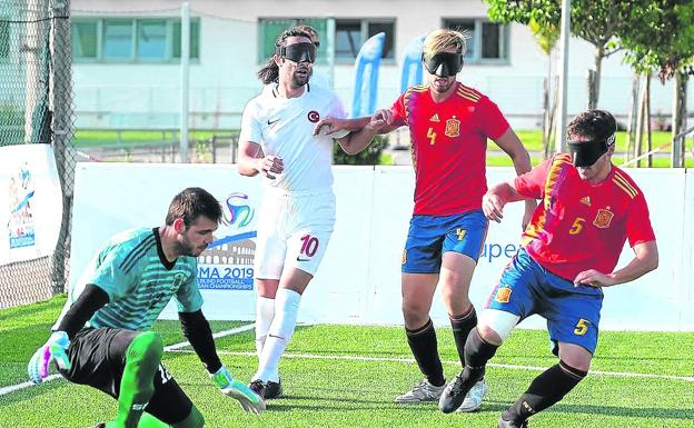 Un jugador de la selección española trata de regatear al portero del equipo rival. 