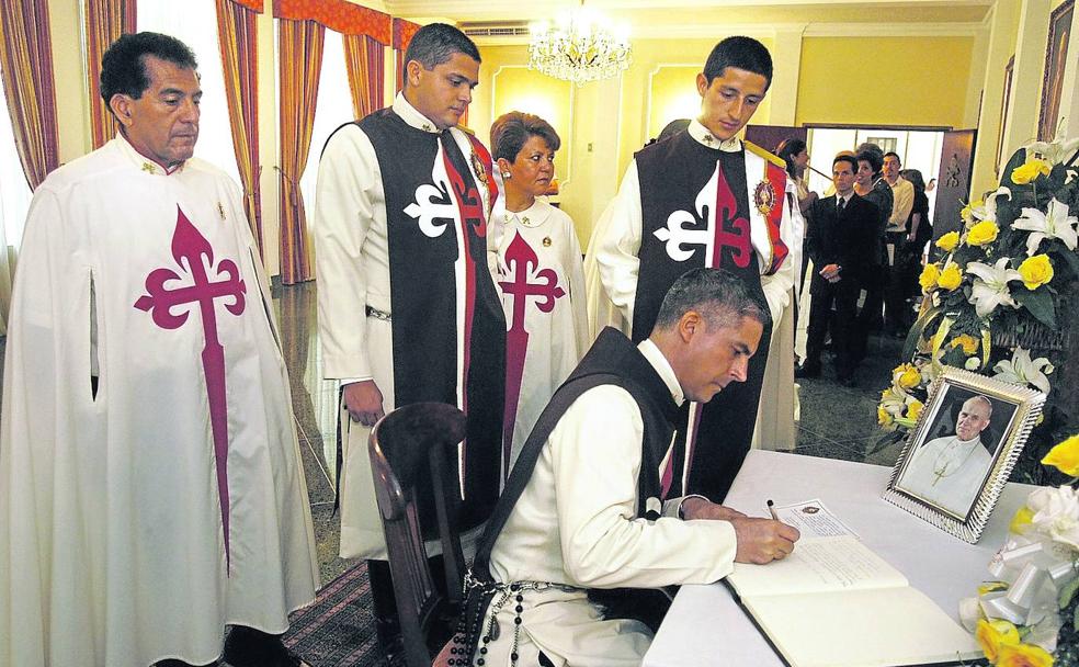 Miembros del movimiento Heraldos del Evangelio firman en un libro de honor.