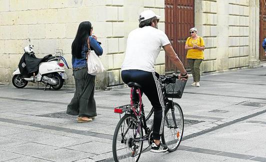 Un ciclistas circula por la Calle Mayor.