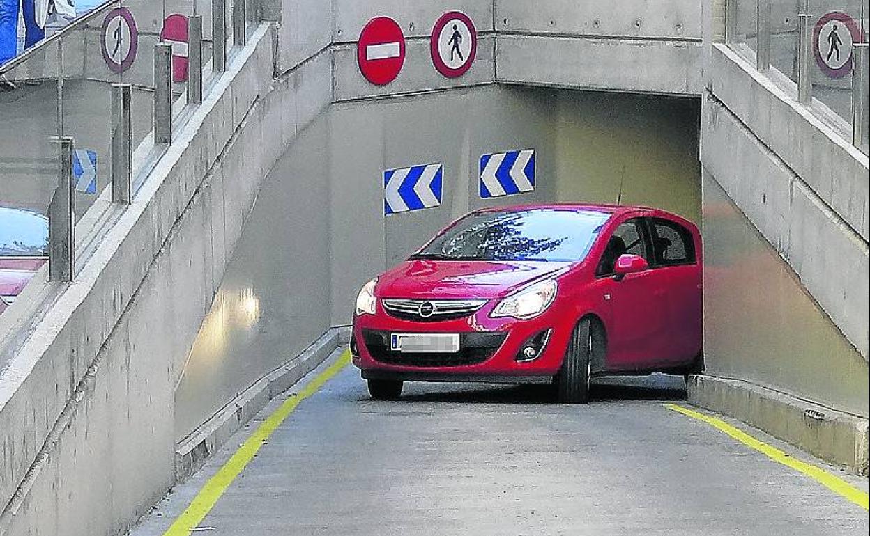 Un coche supera la esquina de la curva (llena de marcas de bordillazos) en la pronunciada rampa de salida de la calle Molinos. 