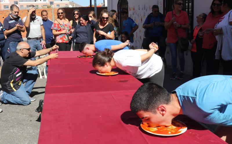 Participantes en el concurso de comer sin manos en el barrio de Pilarica de Valladolid.