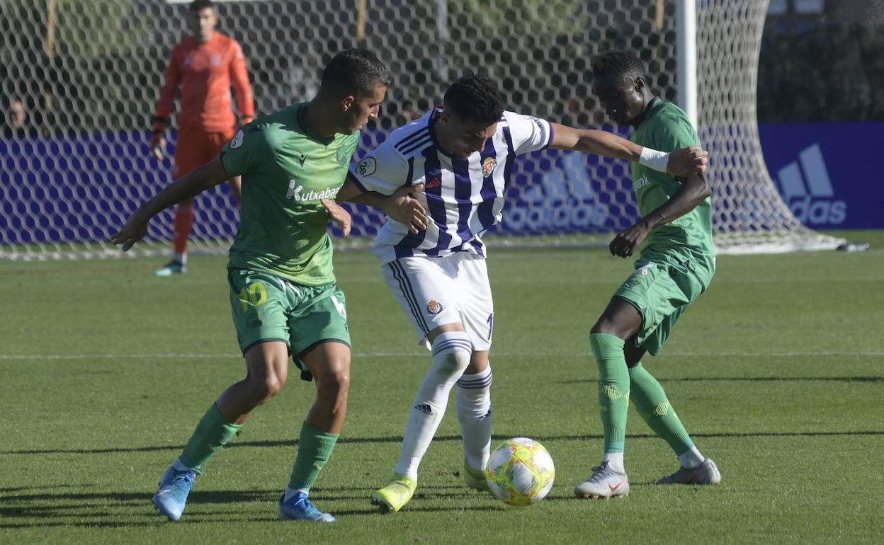 Kike intenta zafarse de la presión de Roberto López y Djouahra, de la Real Sociedad B. 