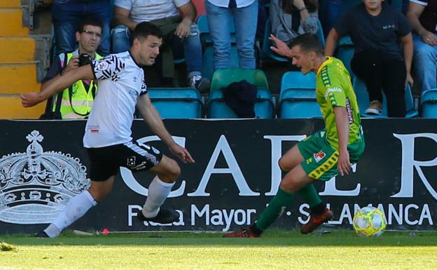 Uxío golpea el balón fuera del campo ante Pedro López antes de asistir a Gio para el 1-0 del Salamanca CF UDS. 