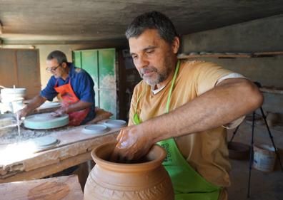 Imagen secundaria 1 - Javier Velasco (polo azul) y sue hermano Óscar Velasco (camiseta amarilla) trabajan en su taller de Portillo (Valladolid).