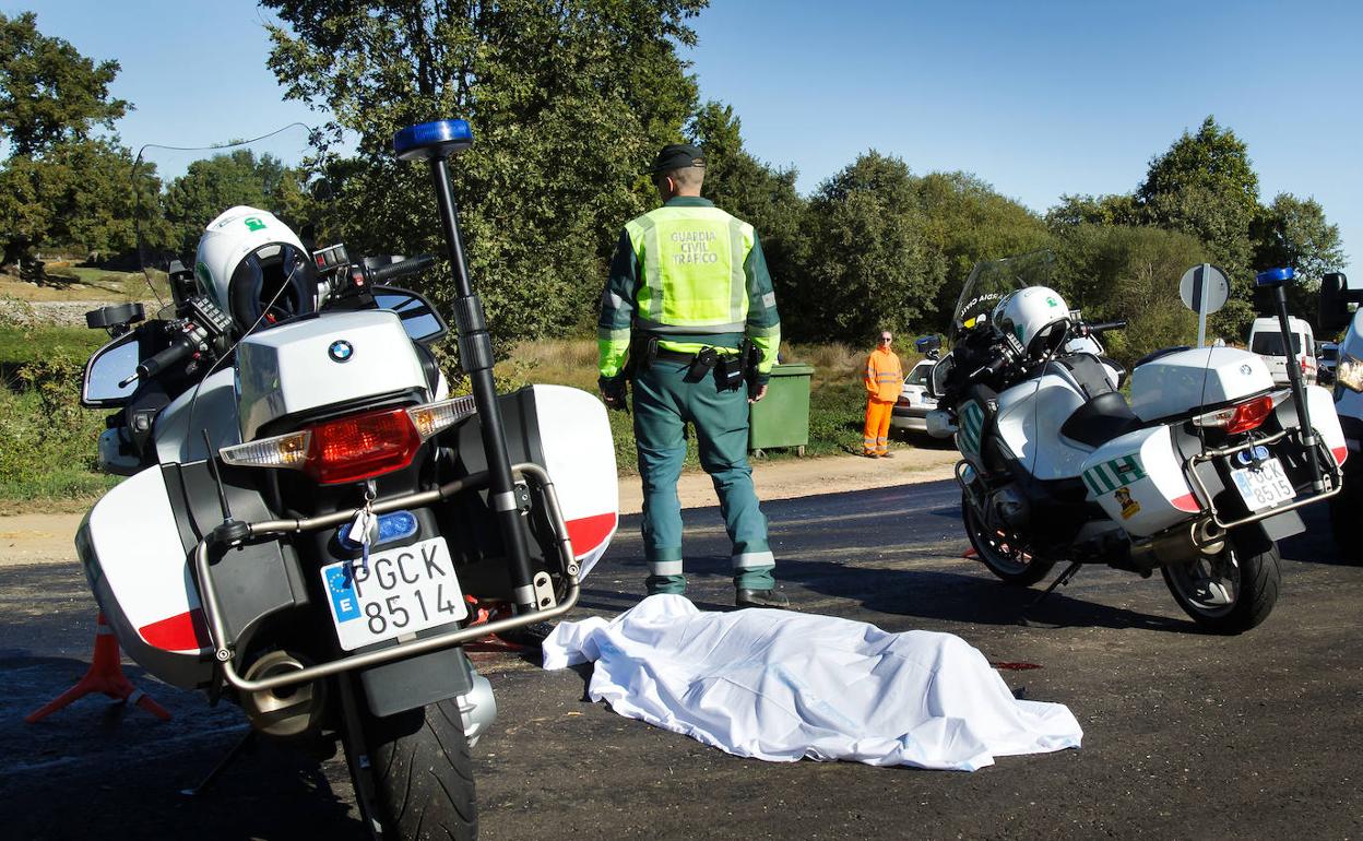 Un agente de la Guardia Civil, junto al cadáver del motorista.