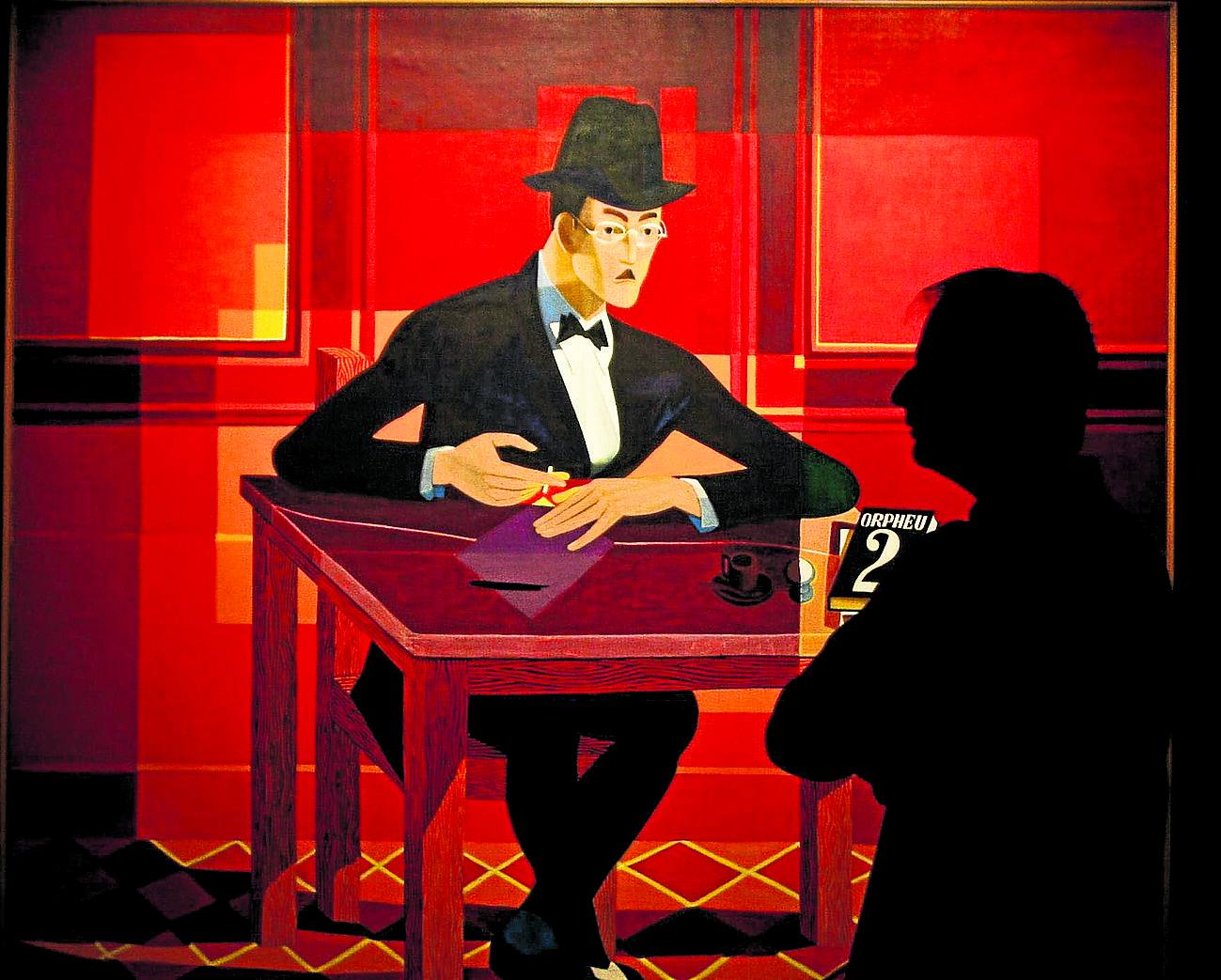 Un hombre junto a un retrato de Pessoa en una exposición dedicada al escritor en Lisboa en 2012.