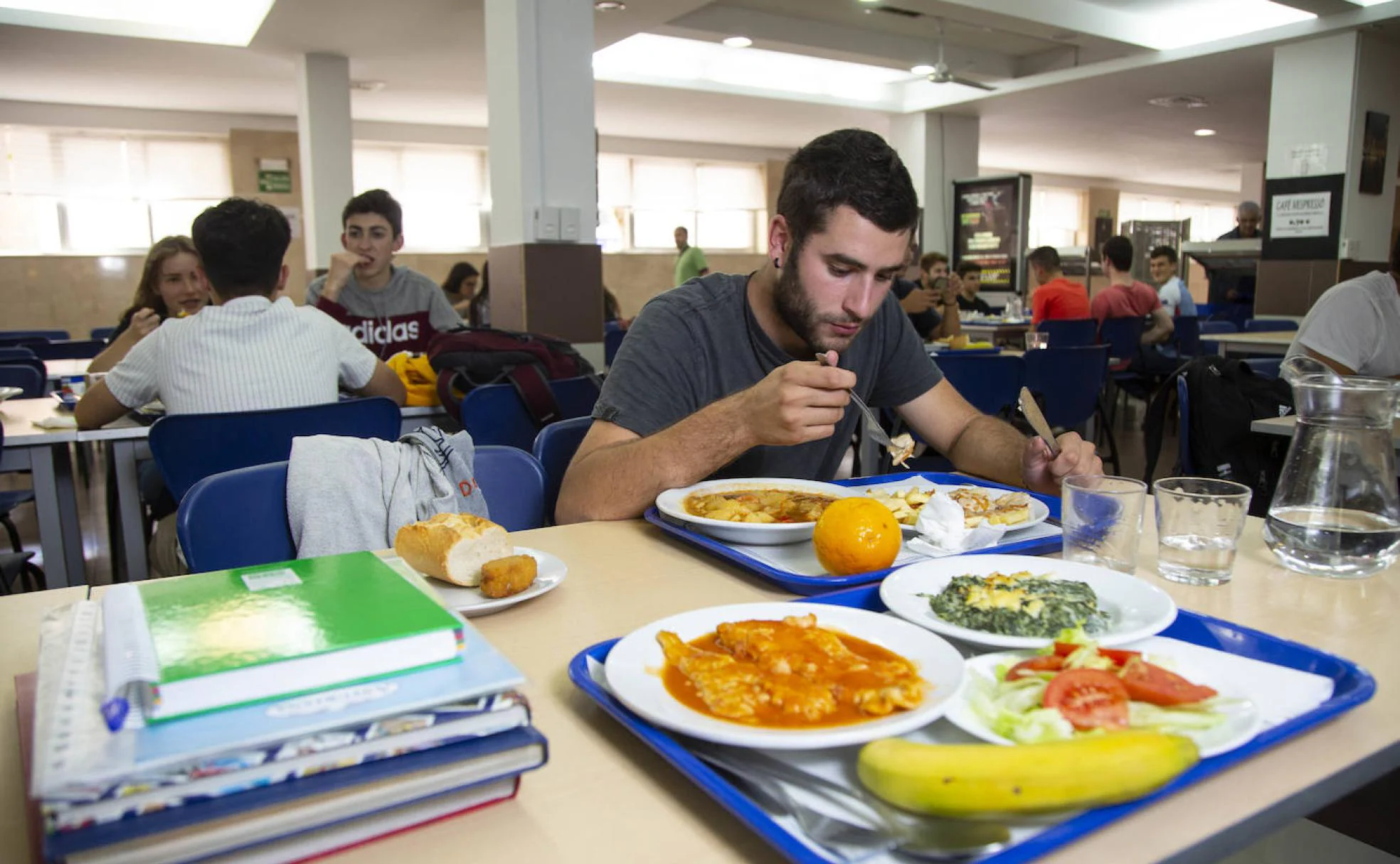 Un alumno come en el un comedor universitario tras una jornada de estudio. 
