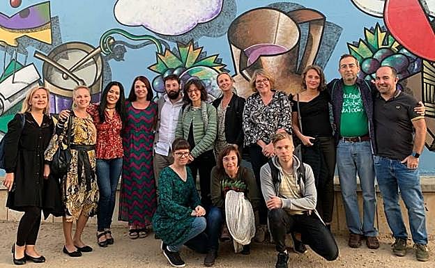 Los profesores posan delante de uno de los murales de Sierra, en Muccientes. 