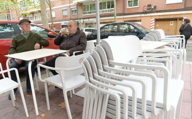 Dos vecinos de Pajarillos disfrutan este lunes de una terraza situada en el barrio. 