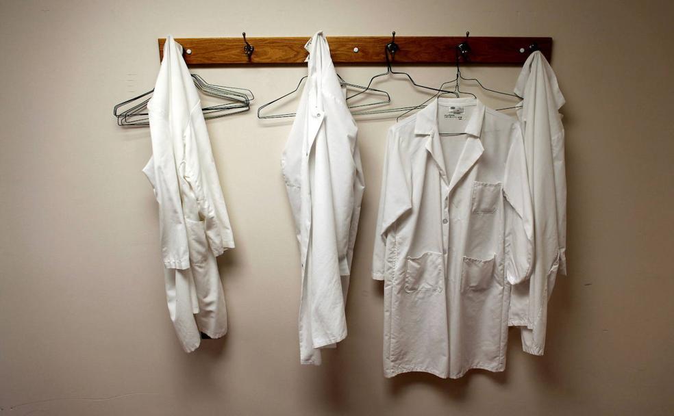 Batas de médicos colgadas en un perchero en un centro de salud. 