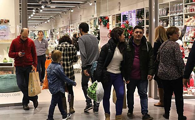 Clientes realizan sus compras en un centro comercial.