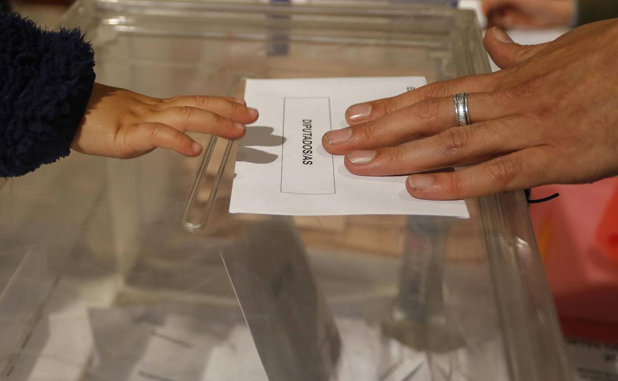 Un niño toca el sobre de votación en una urna el pasado mes de abril. 