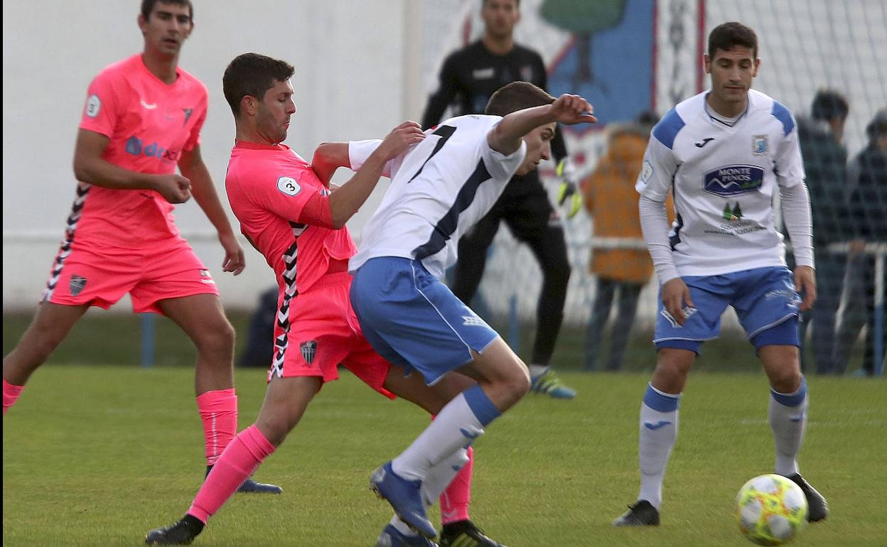 Manu, capitán de la Segoviana, trata de impedir el control del balón de un jugador del Almazán. 