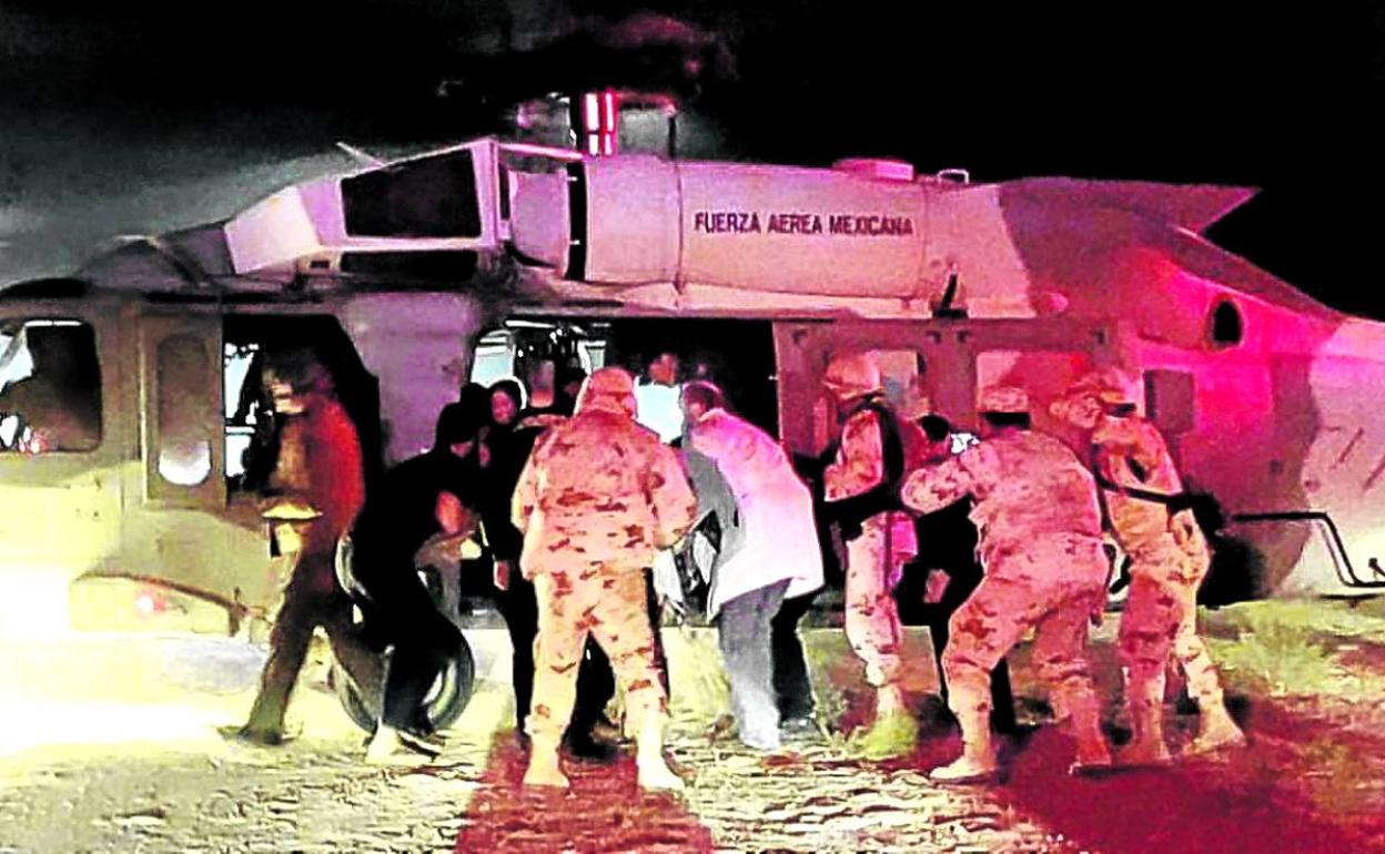 Personal sanitario y de la fuerza aérea trasladan a cinco supervivientes de la matanza.