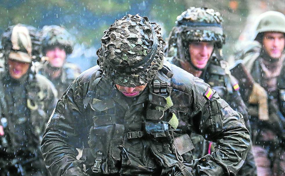 Soldados de las Fuerzas Armadas españolas realizan una marcha bajo la lluvia.