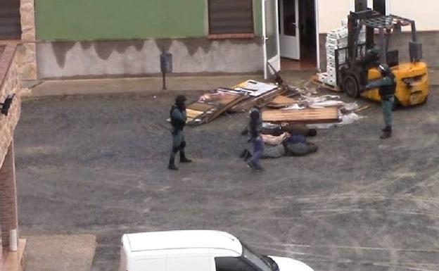 Imagen principal - Arriba, agentes inmovilizan a los tres primeros detenidos. Abajo, la pistola encontrada en el chalé de la finca de Toledo y cajas de piñas tropicales entre las que venía la droga. 