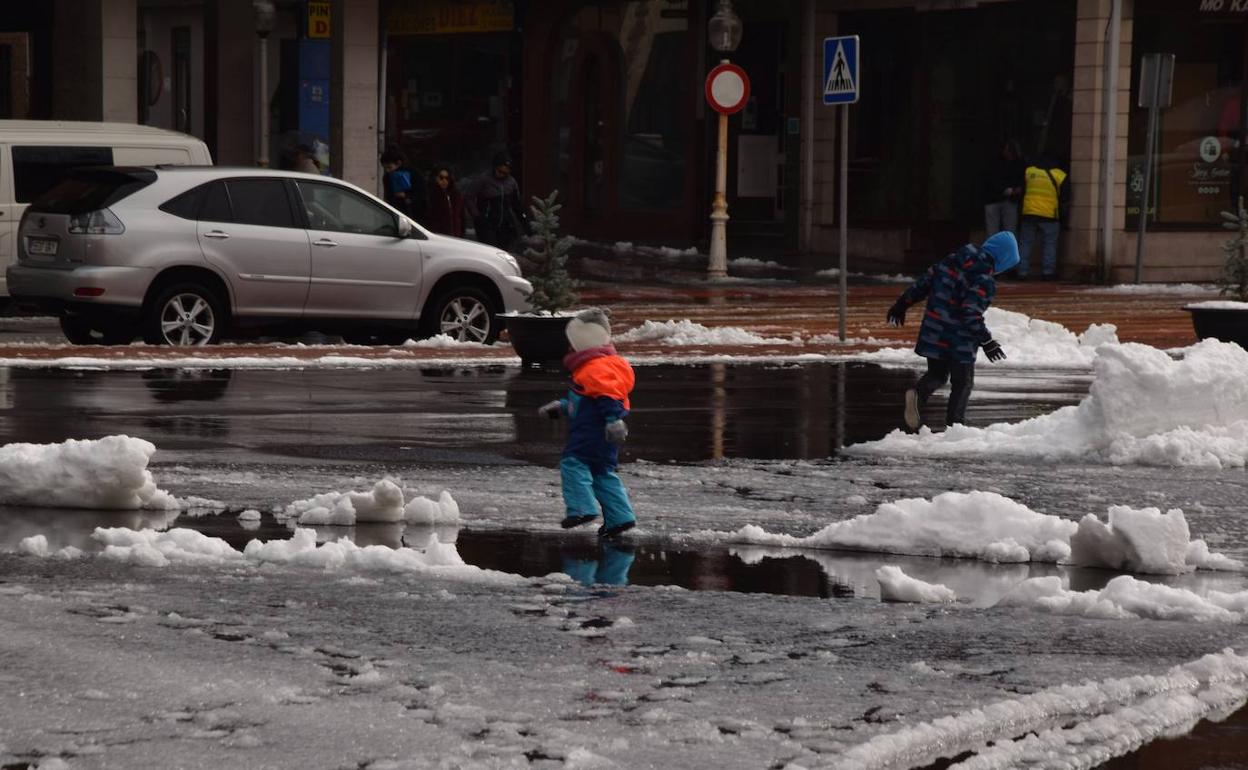 Dos niños juegan con la nieva caída en las últimas horas en Guardo. 