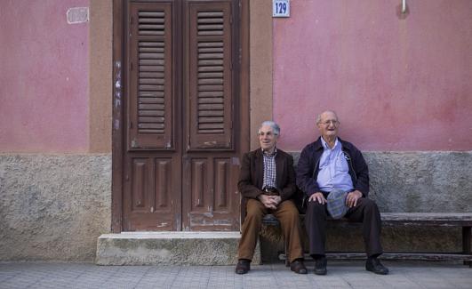 Dos ancianos sentados junto a una casa en Campofelice di Fitalia