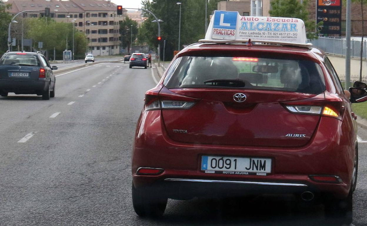 Un coche de una autoescuela de Segovia circula por la carretera de La Granja. 