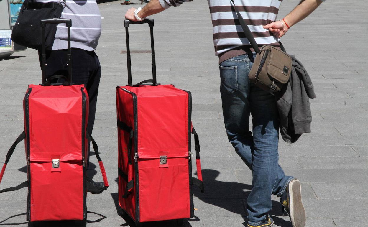 Dos turistas con maletas en Segovia. 