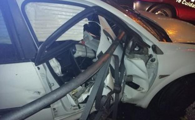 Imagen principal - El coche fue retirado por la grúa con parte de la barandilla en a zona del copiloto.