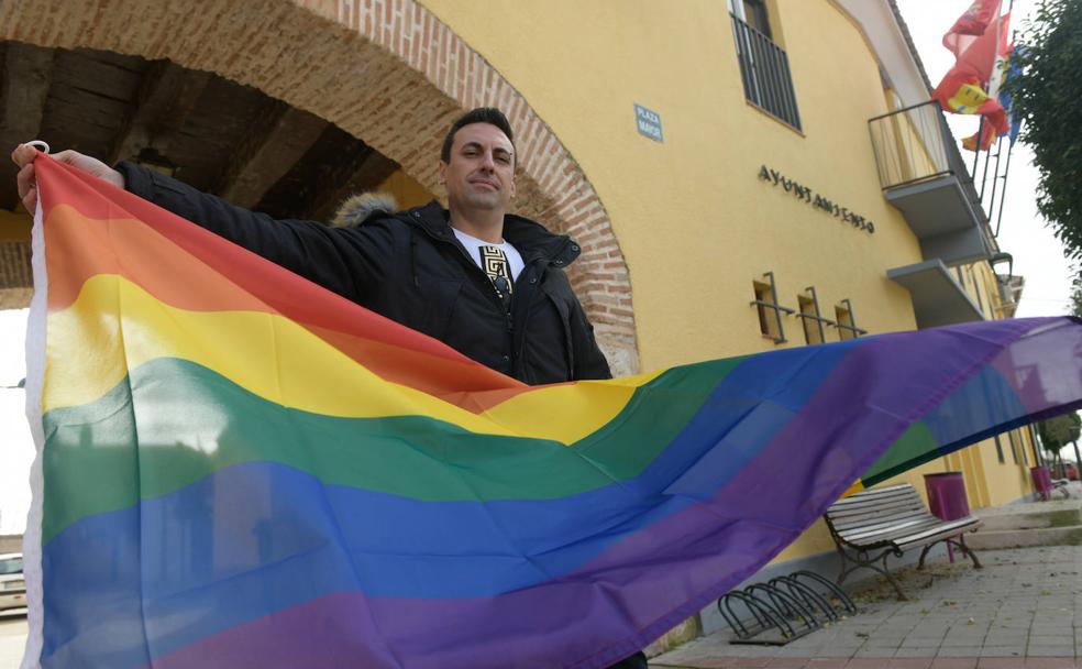 Diego del Pozo ondea la bandera del colectivo LGTB frente al Ayuntamiento de San Miguel del Pino. 