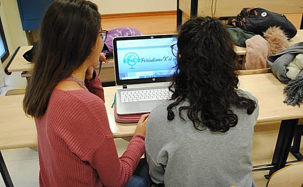 Iris Simón e Iris Sánchez, en un aula de Filosofía y Letras actualizando su medio digital, 'Periodismo X el clima'. 