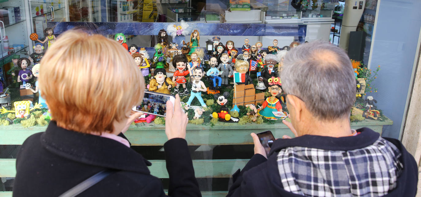 Dos personas fotografían el Belén con figuras de fimo de la calle Torrecilla. 