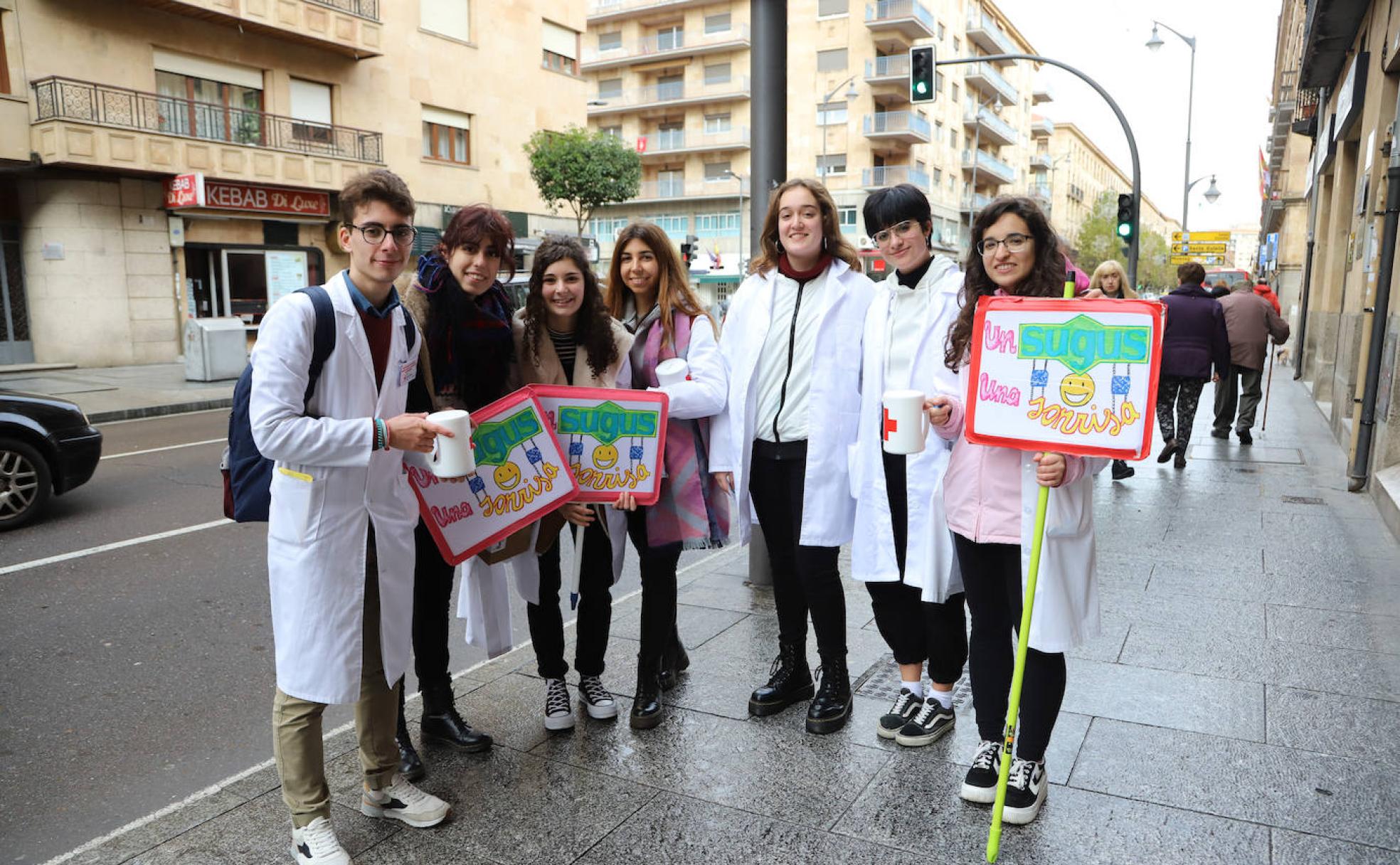 Varios alumnos de Medicina posan con los carteles y las huchas de la campaña solidaria.