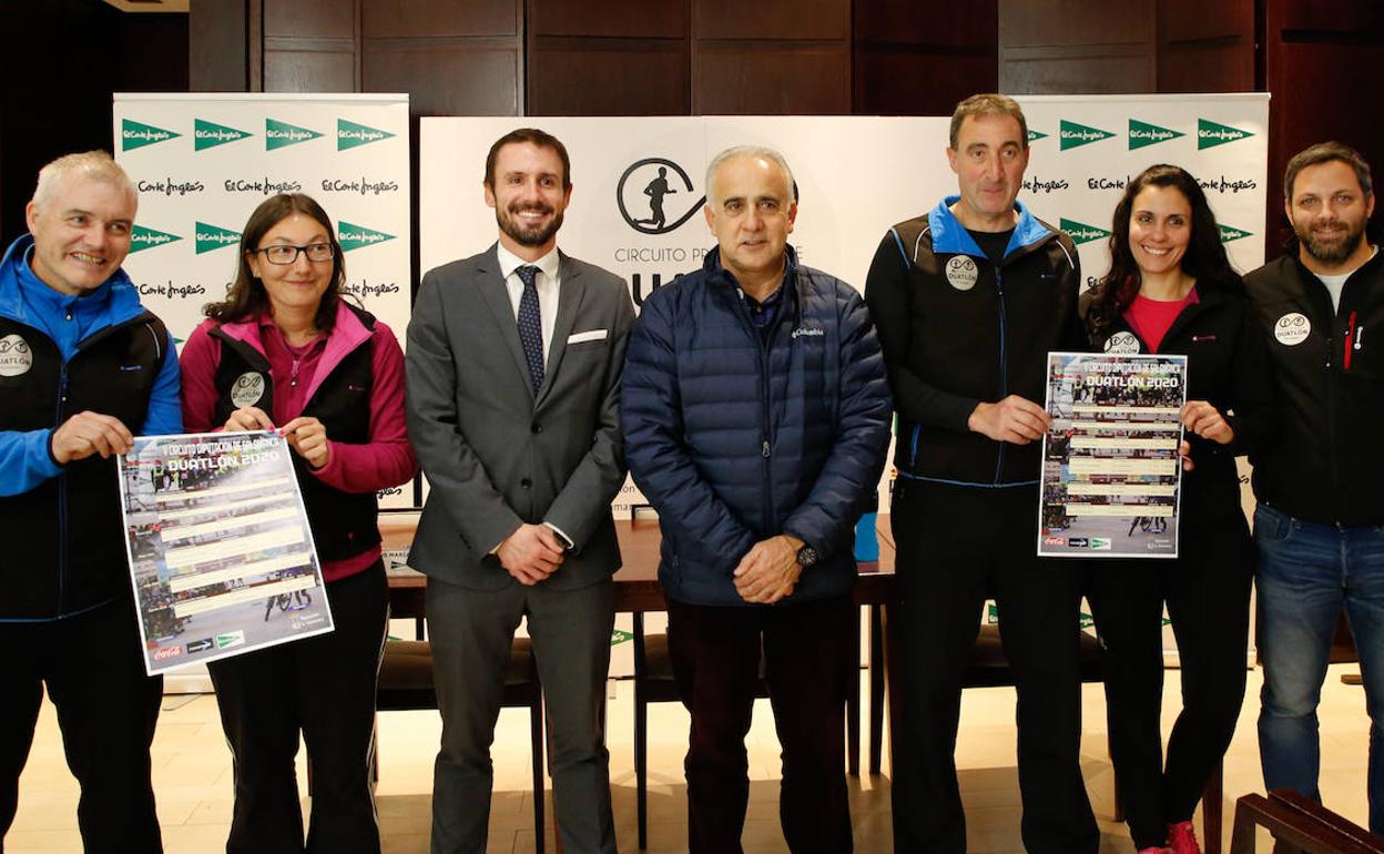 Los organizadores posan con los carteles del circuito de duatlón. 