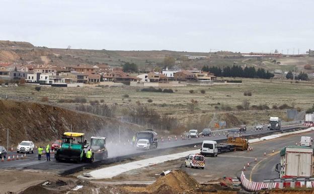 Operarios trabajan en el tramo este de la SG-20 al tiempo que circulan varios vehículos. 