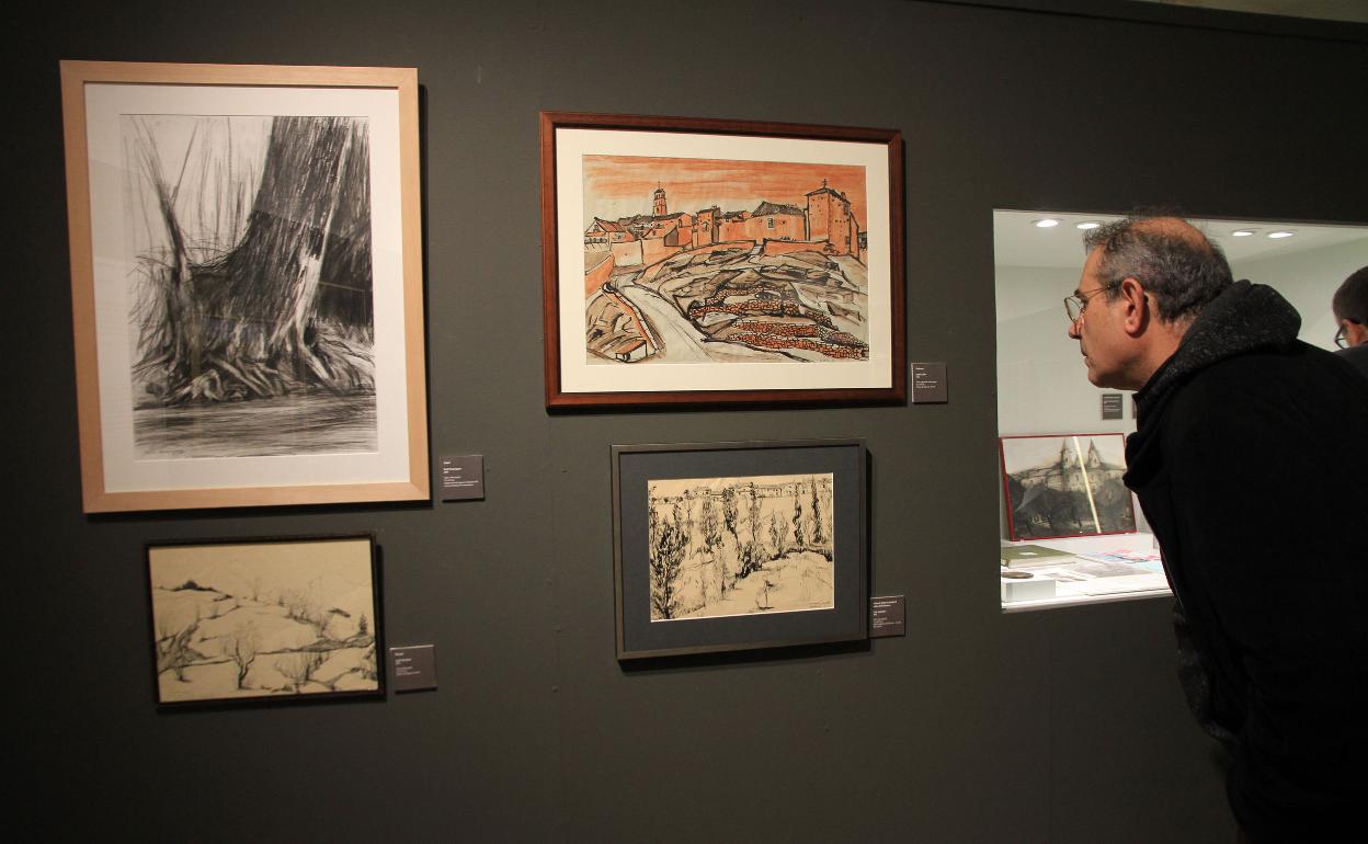 Un hombre observa algunos de los cuadros de la exposición. 
