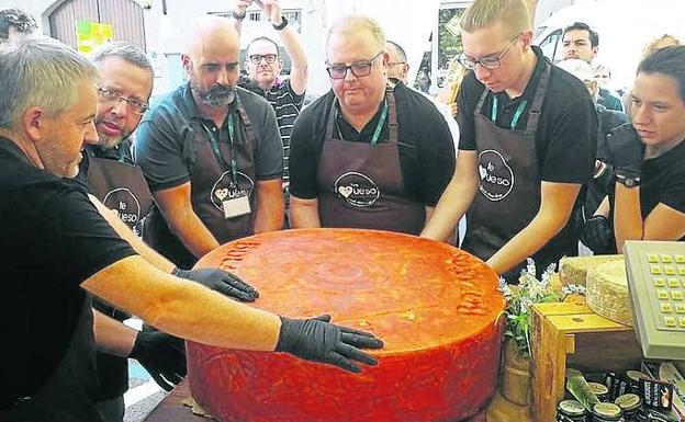 Imagen principal - Feria 'Cheese Naturales e Possible'. Los quesos canarios debutaron en este certamen italiano con uno de 135 kilos elaborado por la quesería grancanaria Bolaños. En la fotografía, el proceso de corte.