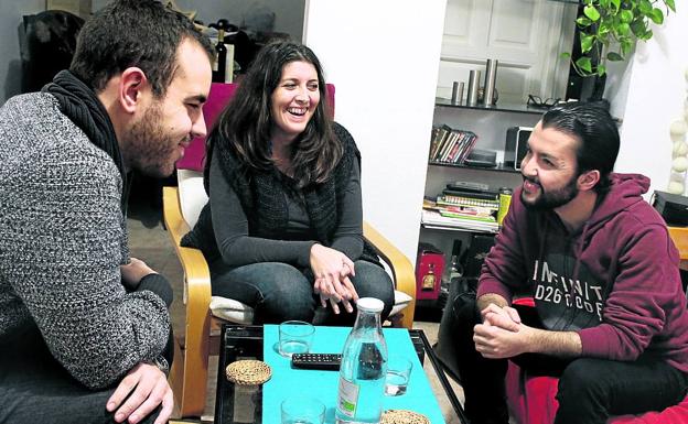 Imagen principal - Alaa Eddin, Laura y Pablo, de Madrid, charlan durante una convivencia; Kevin (izquierda) posa con Assun, Lolo y su familia, Rebeca y Gladys y en la última fotografía, la tarjeta roja que reconoce como solicitante de asilo.