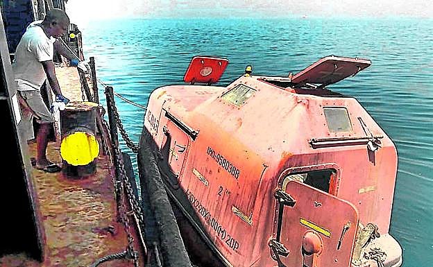 Uno de los marineros observa la lancha salvavidas con la que llegaron hasta Dubái. 