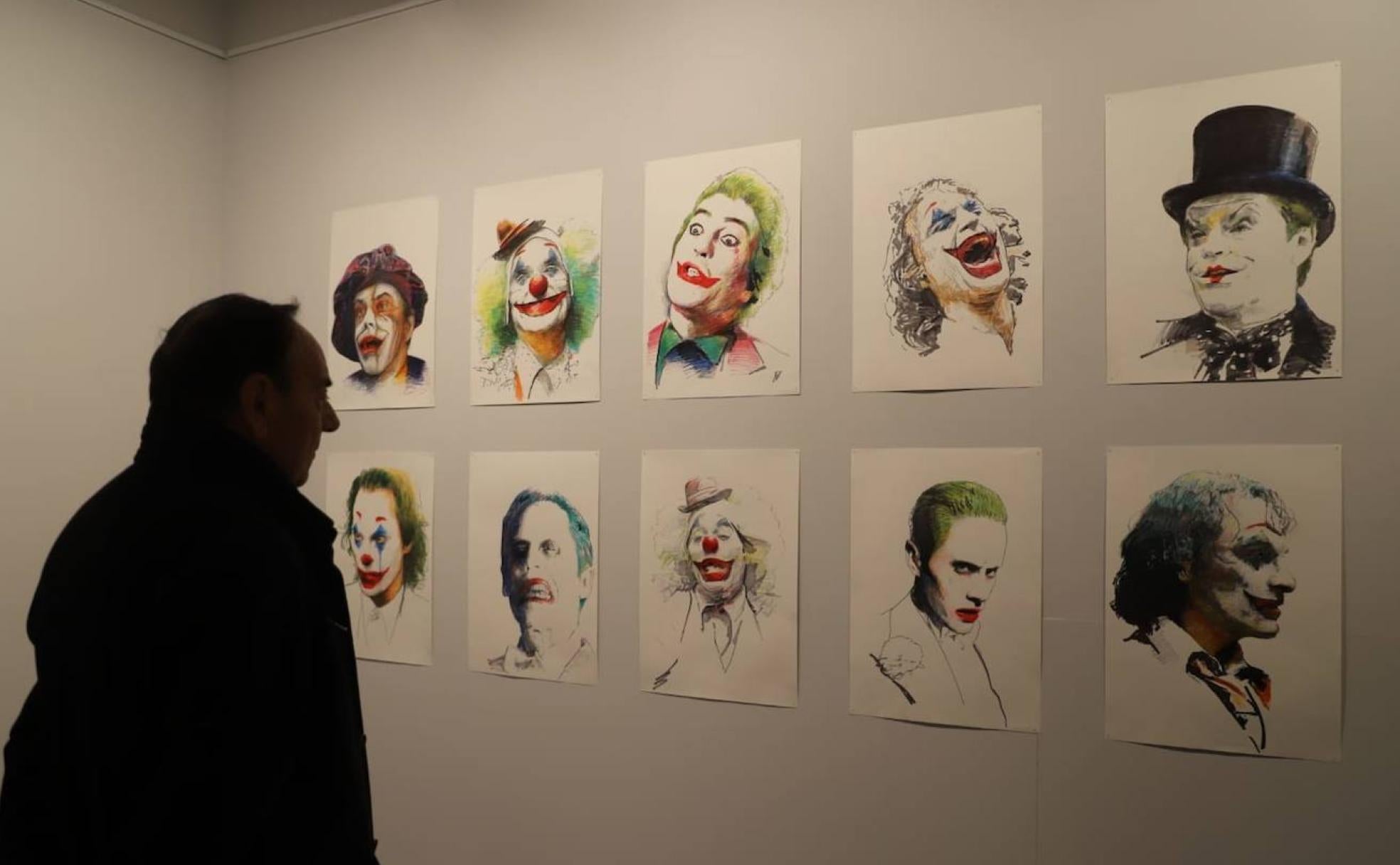 Un espectador admira varios dibujos inspirados en el Joker. 