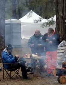 Imagen secundaria 2 - Acampados en el recinto de El Hoyal, con las hogueras ya humeantes y las motos aparcadas y las viandas preparadas. 