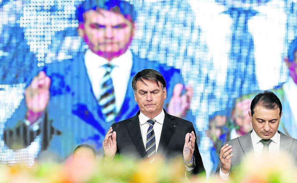 El presidente brasileño, Jair Bolsonaro, reza en un acto evangélico en Camboriú. 