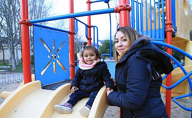 Likza juega con su hija Alyson en unos columpios de la ciudad. 