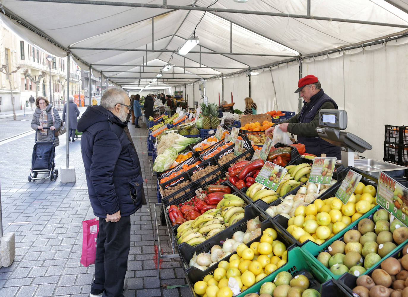 Los puestos del mercado de la Marquesina de la plaza de España se han trasladado hoy, y allí permanecerán durante las próximas cuatro semanas, a la calle Muro, donde se han habilitado carpas sobre el espacio de aparcamiento para vehículos más próximo a la plaza de Madrid.